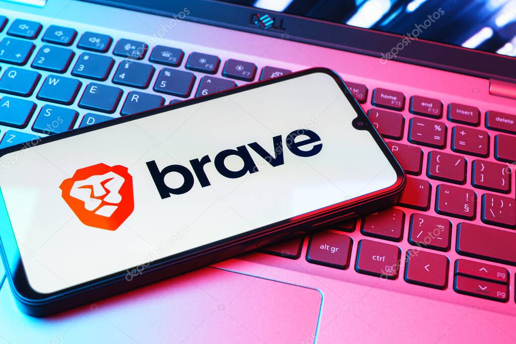 Prague, Czechia - 08 01 2025: A mobile phone lying on a laptop keyboard displays the Brave logo. Brave is a web browser focused on privacy and speed.