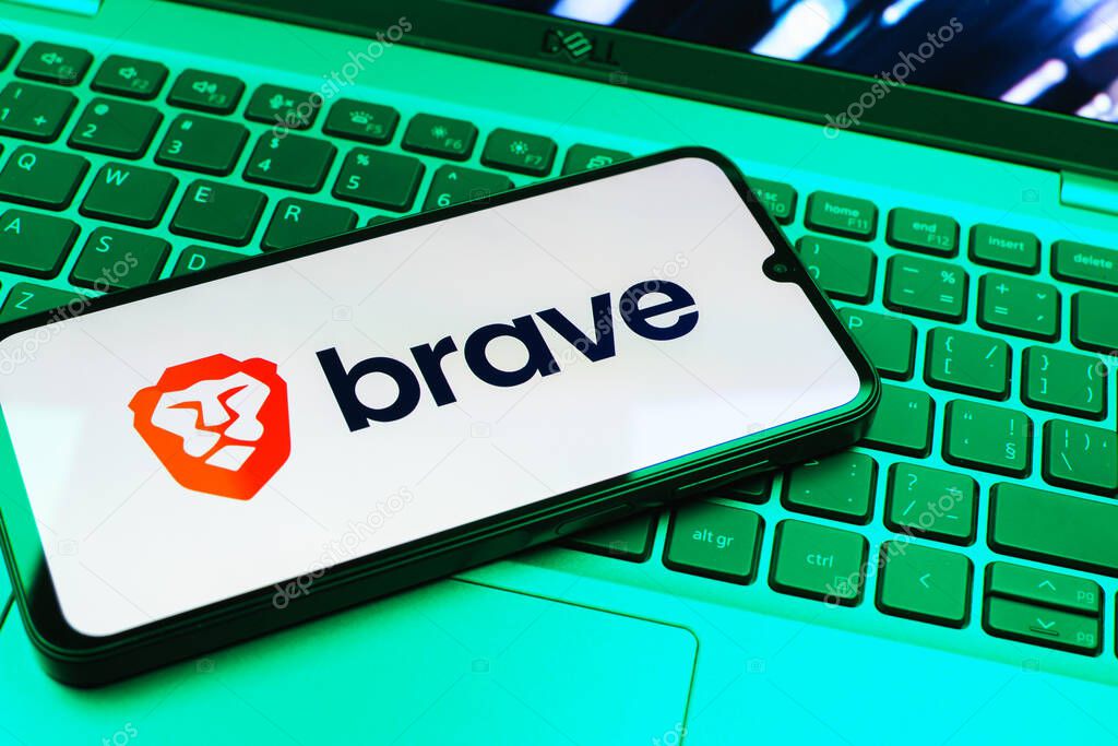 Prague, Czechia - 08 01 2025: A mobile phone lying on a laptop keyboard displays the Brave logo. Brave is a web browser focused on privacy and speed.