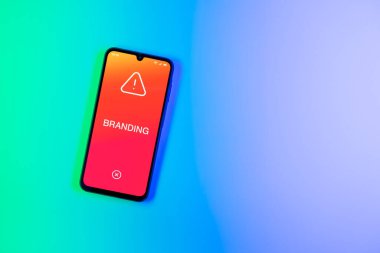 Arka planda Marka metnini gösteren telefon var. Markalaşma tanınabilir bir şirket veya işveren imajı oluşturmaktır.