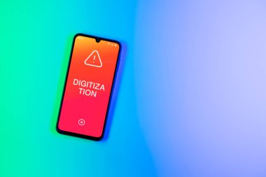 Arka plandaki telefon dijitalleştirme metnini görüntüler. Sayısallaştırma, süreçleri veya verileri dijital forma dönüştürmektir.