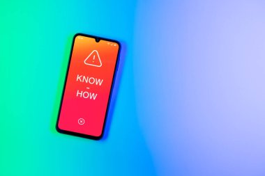 Arka plandaki telefon çokbilmiş metni görüntüler. Bilgi tecrübeyle kazanılır..