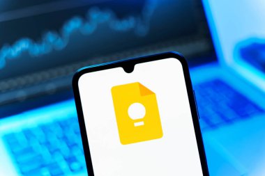 Prag, Çek Cumhuriyeti - 08 12 2025: Bir dizüstü bilgisayarın önünde duran bir cep telefonu Google Keep logosunu gösteriyor. Google Keep notlar, listeler ve hatırlatıcılar için bir platformdur.