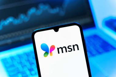 Prag, Çek Cumhuriyeti - 08 12 2025: Dizüstü bilgisayarın önünde duran bir cep telefonu MSN logosunu gösteriyor. MSN haber, e-posta ve çevrimiçi hizmetler için bir platformdur.