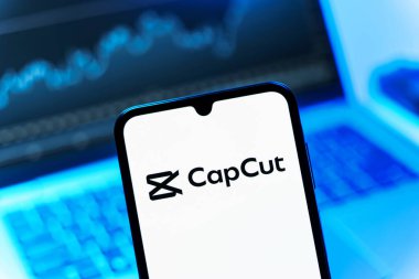 Prag, Çek Cumhuriyeti - 08 12 2025: Bilgisayarın önünde duran bir cep telefonu CapCut logosunu gösteriyor. CapCut video düzenleme ve oluşturma için bir platformdur.