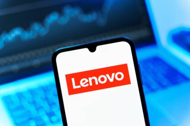 Prag, Çek Cumhuriyeti - 08 12 2025: Bilgisayarın önünde duran bir cep telefonu Lenovo logosunu gösteriyor. Lenovo bilgisayar ve elektronik üreten bir teknoloji şirketidir..