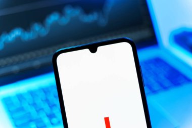 Prague, Czechia - 08 12 2025: A mobile phone standing in front of a laptop displays the FedEX logo. FedEX is a logistics company providing shipping and courier services.