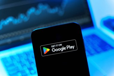 Prag, Çek Cumhuriyeti - 08 12 2025: Bir dizüstü bilgisayarın önünde duran bir cep telefonu Google Play logosunu gösteriyor. Google Play uygulamaları, oyunları ve dijital içeriği indirmek için bir platformdur.