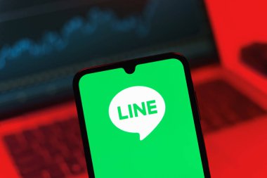 Prag, Çek Cumhuriyeti - 08 12 2025: Dizüstü bilgisayarın önünde duran bir cep telefonu Line logosunu gösteriyor. Line aramalar, mesajlar ve çokluortam paylaşımı için bir mesajlaşma uygulamasıdır.