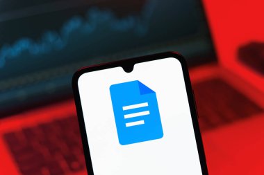 Prag, Çek Cumhuriyeti - 08 12 2025: Bilgisayarın önünde duran bir cep telefonu Google Docs logosunu görüntüler. Google Docs metin belgeleri oluşturmak ve düzenlemek için bir platformdur.