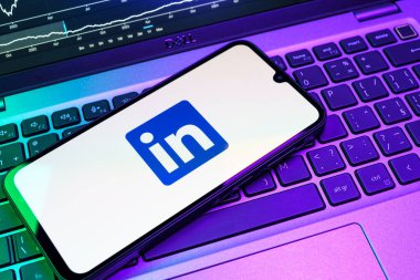 Prag, Çek Cumhuriyeti - 08 18 2025: Klavyede bir cep telefonu LinkedIn logosunu gösterir. LinkedIn, insanları ve şirketleri birbirine bağlayan profesyonel bir ağ..