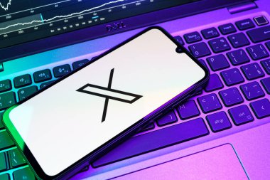 Prag, Çek Cumhuriyeti - 08 18 2025: Klavyede bir cep telefonu X logosu sergiler. X, kısa gönderileri ve güncellemeleri paylaşmak için bir platformdur.