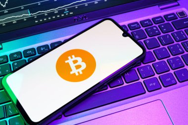 Prag, Çek Cumhuriyeti - 08 18 2025: Klavyede bir cep telefonu Bitcoin logosu sergiler. Bitcoin merkezi olmayan işlemler için dijital bir kripto para birimidir.