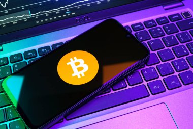 Prag, Çek Cumhuriyeti - 08 18 2025: Klavyede bir cep telefonu Bitcoin logosu sergiler. Bitcoin merkezi olmayan işlemler için dijital bir kripto para birimidir.