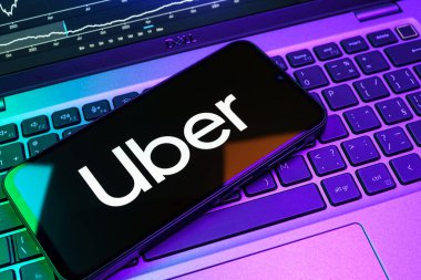 Prag, Çek Cumhuriyeti - 08 18 2025: Klavyede bir cep telefonu Uber logosu sergiler. Uber ulaşım ve dağıtım hizmetleri için bir gezinti selamlama uygulaması.