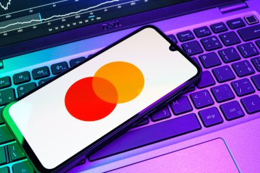 Prag, Çek Cumhuriyeti - 08 18 2025: Klavyede bir cep telefonu Mastercard logosu sergiler. Mastercard ödeme kartları ve hizmetler sağlayan bir finans şirketidir..