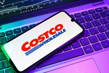 Prag, Çek Cumhuriyeti - 08 18 2025: Klavyede bir cep telefonu Costco logosu sergiler. Costco toptan satış yapan bir perakendecidir. Üyelere toptan ürün satar..