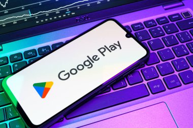 Prag, Çek Cumhuriyeti - 08 18 2025: Bir klavyede bir cep telefonu Google Play logosunu görüntüler. Google Play uygulamaları, oyunları ve dijital içeriği indirmek için bir platformdur.