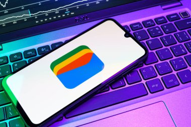 Prag, Çek Cumhuriyeti - 08 18 2025: Bir klavyede bir cep telefonu Google Cüzdan logosunu görüntüler. Google Cüzdanı dijital ödeme yöntemlerini depolamak ve kullanmak için bir platformdur.