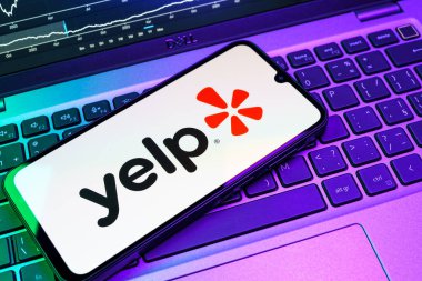 Prag, Çek Cumhuriyeti - 08 18 2025: Klavyede bir cep telefonu Yelp logosu sergiler. Yelp yerel işletmeleri bulmak ve incelemek için bir platformdur.