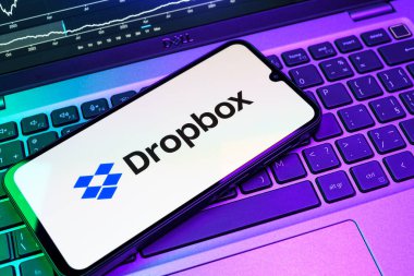 Prag, Çek Cumhuriyeti - 08 18 2025: Klavyede bir cep telefonu Dropbox logosu sergiler. Dropbox bulut depolama ve dosya paylaşımı için bir platformdur.