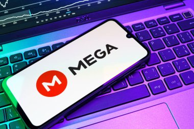 Prag, Çek Cumhuriyeti - 08 18 2025: Klavyede bir cep telefonu Mega logosu sergiler. Mega şifreli dosya paylaşımı ile bulut depolama platformu.