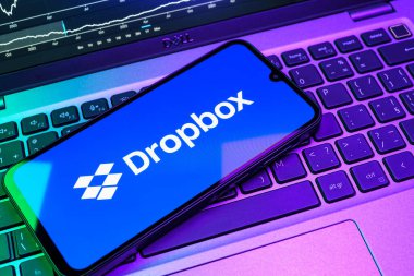 Prag, Çek Cumhuriyeti - 08 18 2025: Klavyede bir cep telefonu Dropbox logosu sergiler. Dropbox bulut depolama ve dosya paylaşımı için bir platformdur.