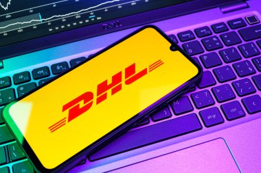 Prag, Çek Cumhuriyeti - 08 18 2025: Klavyede bir cep telefonu DHL logosu sergiler. DHL uluslararası nakliye hizmeti sunan bir lojistik şirketidir..