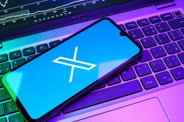 Prag, Çek Cumhuriyeti - 08 18 2025: Klavyede bir cep telefonu X logosu sergiler. X, kısa gönderileri ve güncellemeleri paylaşmak için bir platformdur.