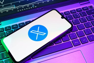 Prag, Çek Cumhuriyeti - 08 18 2025: Klavyede bir cep telefonu X logosu sergiler. X, kısa gönderileri ve güncellemeleri paylaşmak için bir platformdur.