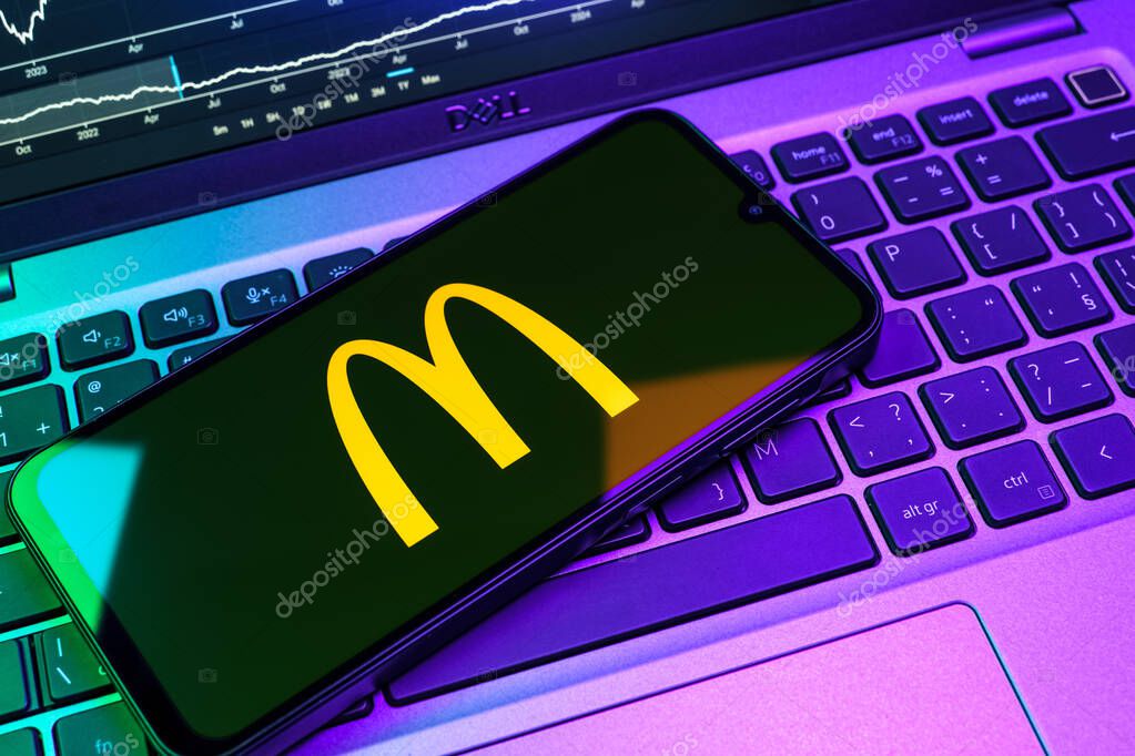 Prague, Czechia - 08 18 2025: A mobile phone on a keyboard displays McDonalds logo. McDonalds is a fast-food chain serving burgers, fries, and more.