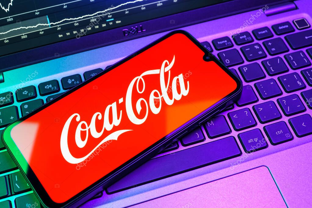 Prague, Czechia - 08 18 2025: A mobile phone on a keyboard displays Coca-Cola logo. Coca-Cola is a beverage company known for its soft drinks.