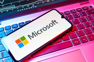 Prag, Çek Cumhuriyeti - 08 18 2025: Klavyede bir cep telefonu Microsoft logosu sergiler. Microsoft yazılım, donanım ve hizmet sunan bir teknoloji şirketidir..