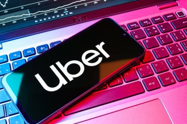 Prag, Çek Cumhuriyeti - 08 18 2025: Klavyede bir cep telefonu Uber logosu sergiler. Uber ulaşım ve dağıtım hizmetleri için bir gezinti selamlama uygulaması.