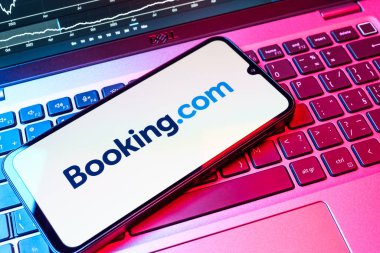 Prag, Çek Cumhuriyeti - 08 18 2025: Klavyede bir cep telefonu Booking.com logosu sergiler. Rezervasyon, otel bulmak ve rezervasyon yaptırmak için bir platformdur..