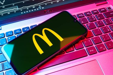 Prag, Çek Cumhuriyeti - 08 18 2025: Klavyede bir cep telefonu McDonalds logosu sergiler. McDonalds hamburger, patates kızartması ve daha fazlası sunan bir fast-food zinciri..