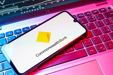 Prag, Çek Cumhuriyeti - 08 18 2025: Bir klavyede bir cep telefonu Commonwealth Bank logosunu gösteriyor. Commonwealth Bank, Avustralya 'da finansal hizmetler sağlayan bir bankadır..