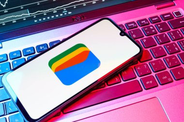 Prag, Çek Cumhuriyeti - 08 18 2025: Bir klavyede bir cep telefonu Google Cüzdan logosunu görüntüler. Google Cüzdanı dijital ödeme yöntemlerini depolamak ve kullanmak için bir platformdur.
