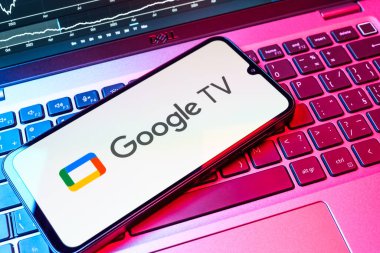 Prag, Çek Cumhuriyeti - 08 18 2025: Bir klavyede bir cep telefonu Google TV logosu görüntüler. Google TV film, program ve uygulamalar için bir platformdur..