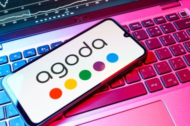 Prag, Çek Cumhuriyeti - 08 18 2025: Klavyede bir cep telefonu Agoda logosu sergiler. Agoda, otelleri ve seyahat yerlerini ayırtmak için bir platform..