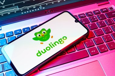 Prag, Çek Cumhuriyeti - 08 18 2025: Klavyede bir cep telefonu Duolingo logosu sergiler. Duolingo interaktif olarak dil öğrenmek için bir platformdur..