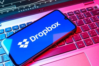 Prag, Çek Cumhuriyeti - 08 18 2025: Klavyede bir cep telefonu Dropbox logosu sergiler. Dropbox bulut depolama ve dosya paylaşımı için bir platformdur.
