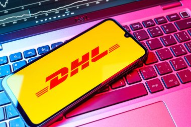 Prag, Çek Cumhuriyeti - 08 18 2025: Klavyede bir cep telefonu DHL logosu sergiler. DHL uluslararası nakliye hizmeti sunan bir lojistik şirketidir..