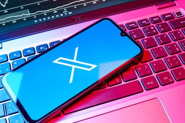 Prag, Çek Cumhuriyeti - 08 18 2025: Klavyede bir cep telefonu X logosu sergiler. X, kısa gönderileri ve güncellemeleri paylaşmak için bir platformdur.