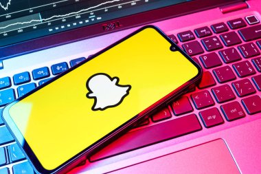 Prag, Çek Cumhuriyeti - 08 18 2025: Klavyede bir cep telefonu Snapchat logosu sergiler. Snapchat fotoğraf, video ve geçici mesajlar göndermek için bir uygulamadır.