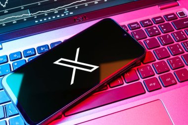Prag, Çek Cumhuriyeti - 08 18 2025: Klavyede bir cep telefonu X logosu sergiler. X, kısa gönderileri ve güncellemeleri paylaşmak için bir platformdur.