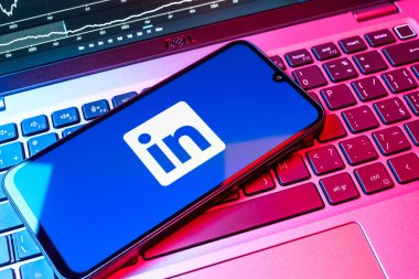 Prag, Çek Cumhuriyeti - 08 18 2025: Klavyede bir cep telefonu LinkedIn logosunu gösterir. LinkedIn, insanları ve şirketleri birbirine bağlayan profesyonel bir ağ..