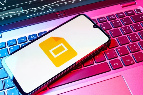 Prag, Çek Cumhuriyeti - 08 18 2025: Klavyede bir cep telefonu Google Slides logosunu görüntüler. Google Slides sunumlar ve slayt gösterileri oluşturmak için bir platformdur.
