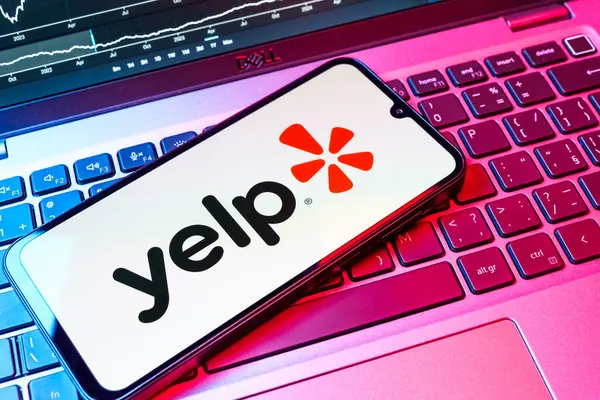 Prag, Çek Cumhuriyeti - 08 18 2025: Klavyede bir cep telefonu Yelp logosu sergiler. Yelp yerel işletmeleri bulmak ve incelemek için bir platformdur.