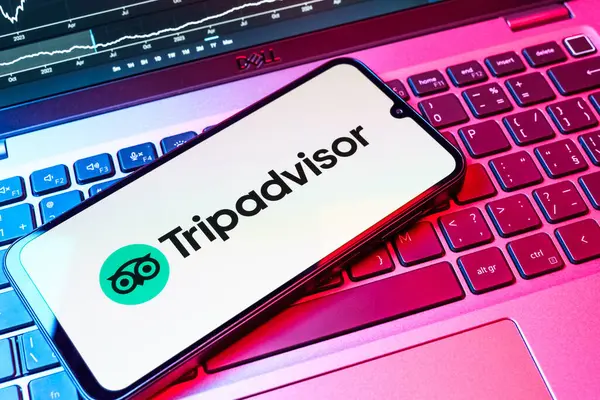 Prag, Çek Cumhuriyeti - 08 18 2025: Klavyede bir cep telefonu TripDanışman logosunu gösteriyor. Seyahat danışmanı seyahat değerlendirmeleri, rezervasyonlar ve tavsiyeler için bir platformdur..