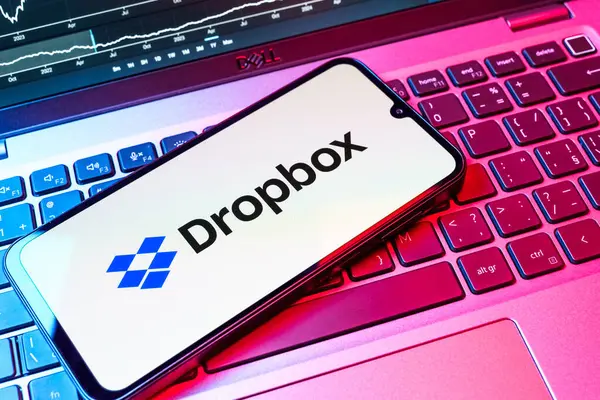 Prag, Çek Cumhuriyeti - 08 18 2025: Klavyede bir cep telefonu Dropbox logosu sergiler. Dropbox bulut depolama ve dosya paylaşımı için bir platformdur.